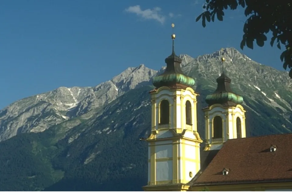 A church with two onion-domed towers against an alpine mountain, the sample photograph this widget pools.