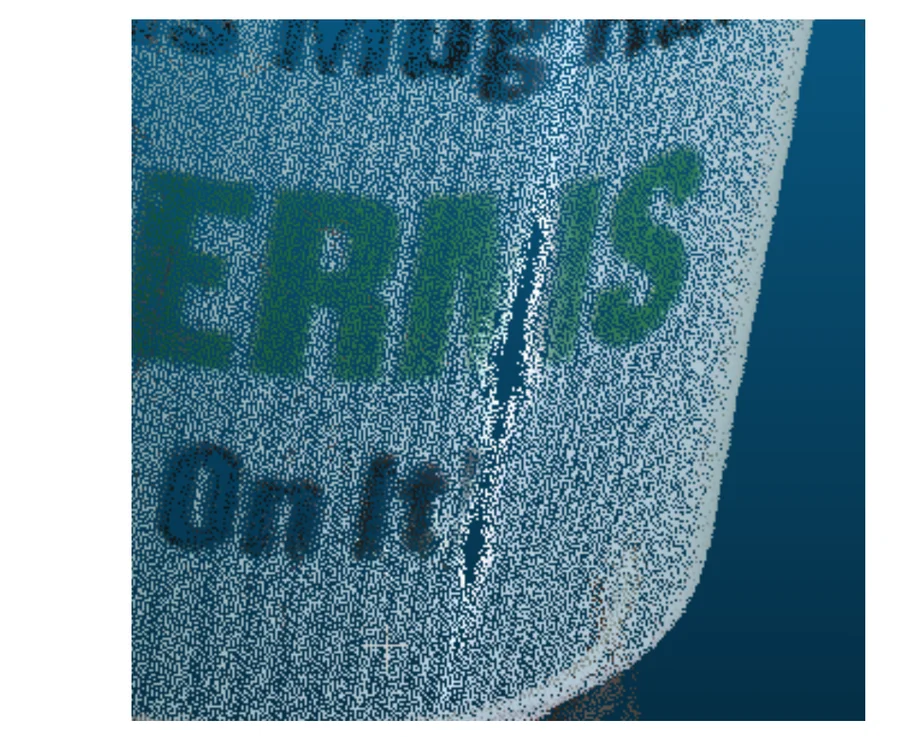 Close-up crop of the mug's point cloud, dense enough that the printed text 'GERMS On It' is legible in the point positions and colours